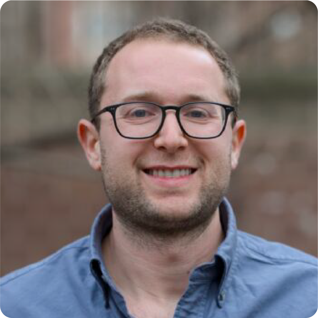 A color photo of a man with glasses.