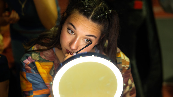 By Devin Flores/Cornell University - A model does her makeup before walking the runway.