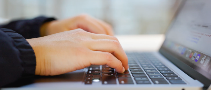 hands typing on a laptop