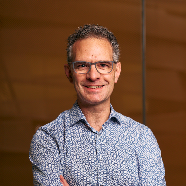 A photo of Stephen Marschner, a smiling man in front of a brown background