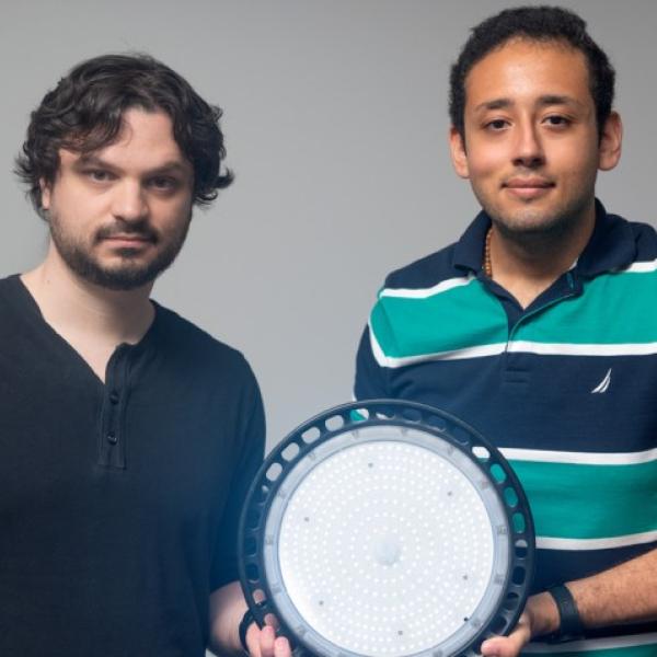 Abe Davis, left, assistant professor of computer science in the Cornell Ann S. Bowers College of Computing and Information Science, and graduate student Peter Michael with a watermark light.