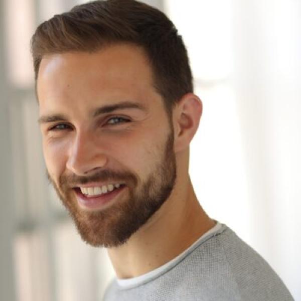 Yann Hicke wears a gray sweater and stares at the camera