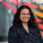 Professor Kavita Bala, smiling headshot, a woman with dark hair in a black shirt.