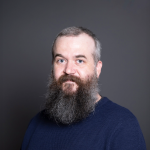 A color photo of Robert Nicholl in front of a grey background