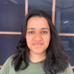 A photo of Tanya Goyal, a woman with shoulder-length dark brown hair in a green shirt.