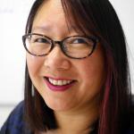 Woman in glasses smiling at camera, 