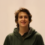 A color photo of a man smiling for a portrait.