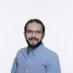 A color photo of a man smiling for a portrait.