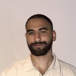 A color photo of a man smiling for a portrait.