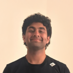 A color photo of a man smiling for a portrait.