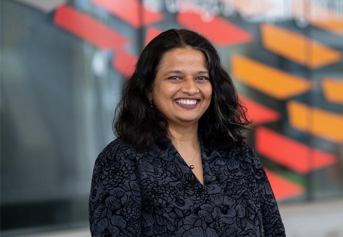 Professor Kavita Bala, smiling headshot, a woman with dark hair in a black shirt.