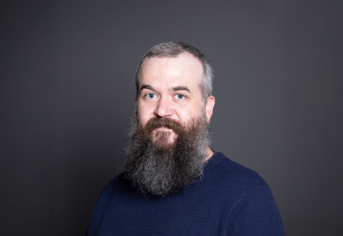 A color photo of Robert Nicholl in front of a grey background
