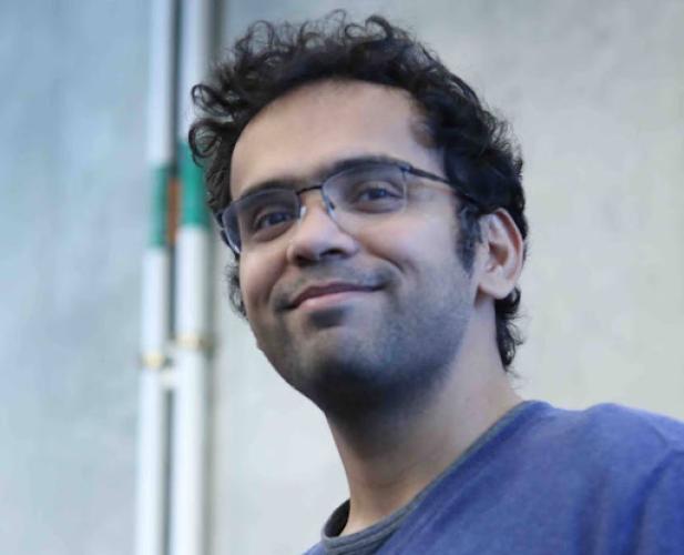 A photo of Sanjiban Choudury, a man with dark hair and glasses in a blue shirt.
