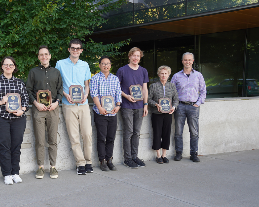 A color photo showing the faculty award winners with their plaques.