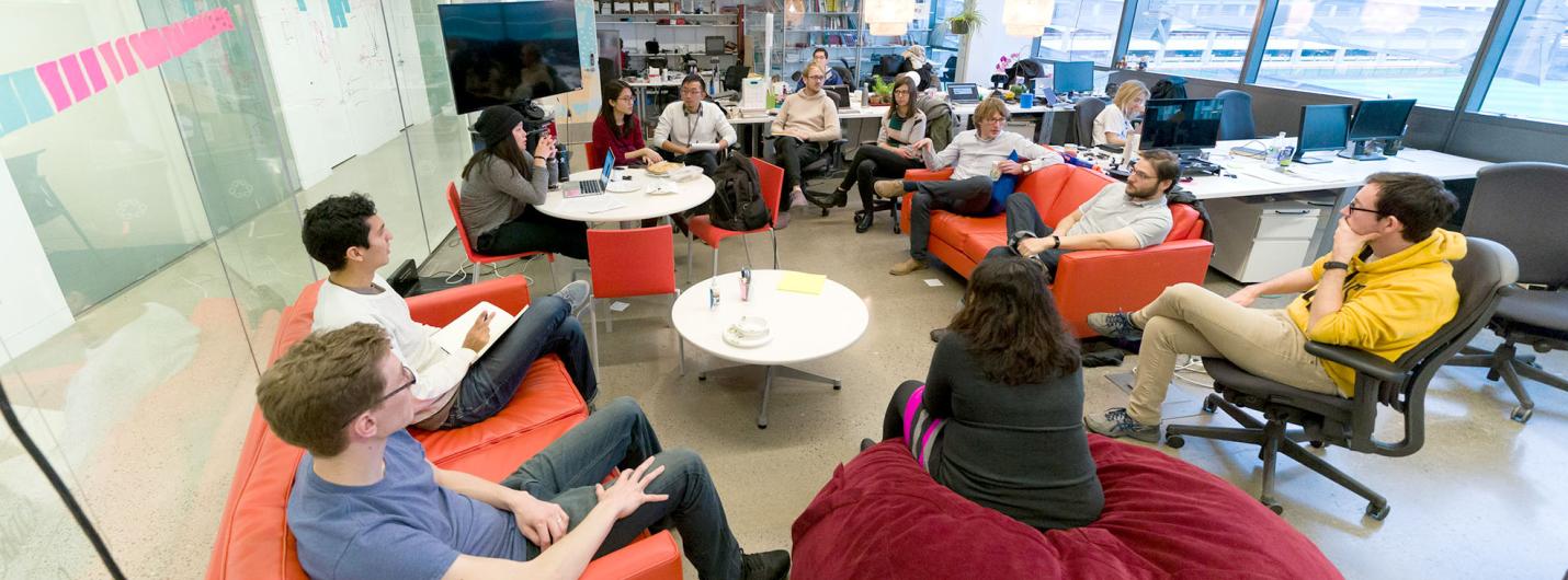 Group of students and faculty having a discussion in a collaborative workspace.